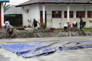Para pekerja mengaduk semen dan pasir untuk cor pembuatan lapangan multifungsi di lingkungan kampus STKIP Hermon Timika. (Foto-Bambang)